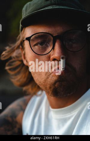 A young man lights a cigarette. Stock Photo