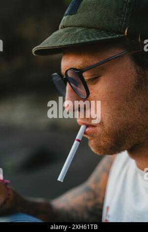 A young man lights a cigarette. Stock Photo