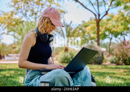 Student working on laptop in a campus park Stock Photo