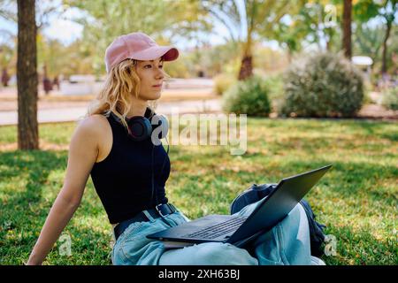 Student working on laptop in a university park Stock Photo