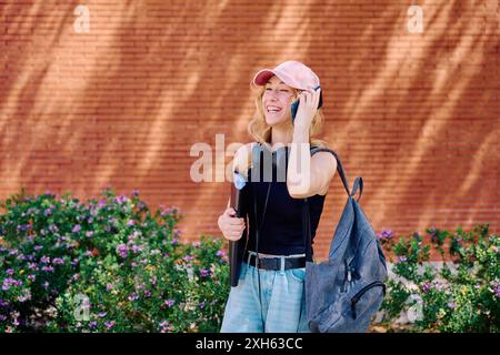 Student talking on phone outside building Stock Photo