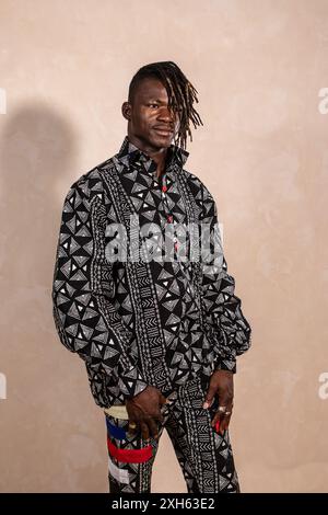 Young adult black man posing in a photo studio wearing traditional african clothing Stock Photo