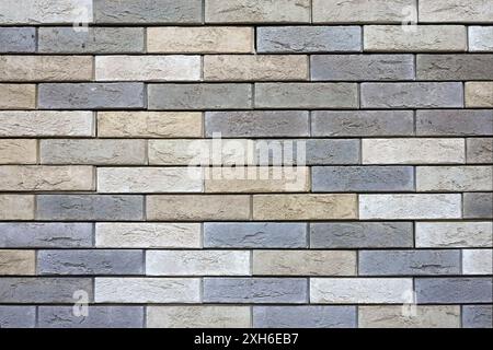 Wall from motley mid size beige decorative spotted bricks horizontal photo front view close up Stock Photo