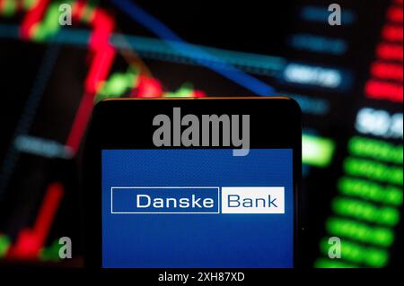 China. 21st June, 2024. In this photo illustration, the Danish Danske Bank (CPH: DANSKE) logo seen displayed on a smartphone with an economic stock exchange index graph in the background. (Photo by Budrul Chukrut/SOPA Images/Sipa USA) *** Strictly for editorial news purposes only *** Credit: Sipa USA/Alamy Live News Stock Photo