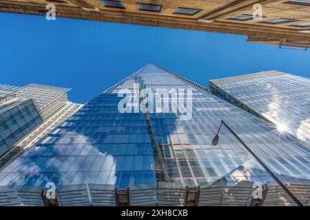 Low angle nadir shot view of modern blue glass skyscraper The Shard with blue sky and clouds reflected in its windows. London. United Kingdom. Stock Photo