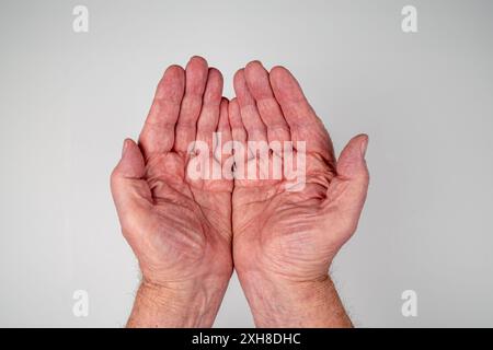 Caucasian male hands cupped together on white background Stock Photo