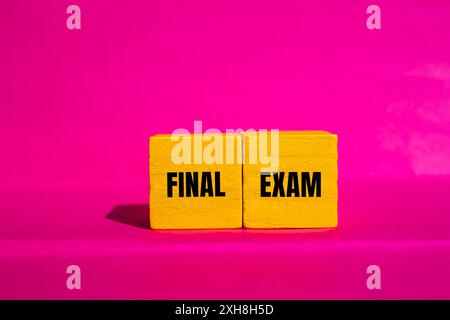 Final exam message written on yellow wooden cubes with pink background. Conceptual final exam symbol. Copy space. Stock Photo