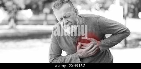 Heart attack. Mature man writhing in pain and pressing hands to chest outdoors. Banner design with space for text Stock Photo