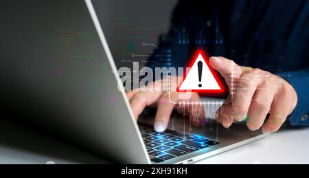 System hacked warning alert. Person use laptop with virtual warning sign for cyber attack. Ransomware, Virus, Spyware, Malware or Malicious software, Stock Photo