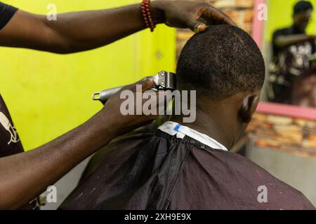 A man is getting his hair cut by a barber in Africa. Stock Photo