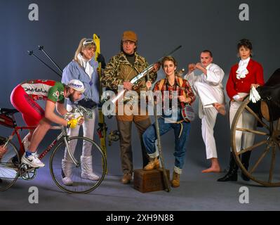 Studio portrait, diverse hobbyists including cyclist, skier, hunter, hiker, martial artist and historic reenactor posing with gear on gray background Stock Photo
