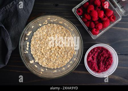 Overnight Oats and Raspberry Compote: Overhead view of rolled oats mixed with almond milk and chia seeds next to a small dish of fruit compote Stock Photo