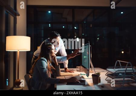 Night, talking or business people on computer for coaching in office for teamwork, helping or technology. Learning software, research and IT Stock Photo