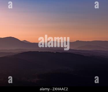 A sunset landscape photo taken from gummers how at viewpoint which shows the Lake District fells at a dramatic golden hour. Stock Photo