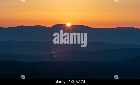 A sunset landscape photo taken from gummers how at viewpoint which shows the Lake District fells at a dramatic golden hour. Stock Photo