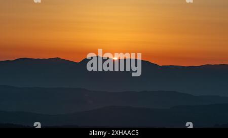 A sunset landscape photo taken from gummers how at viewpoint which shows the Lake District fells at a dramatic golden hour. Stock Photo