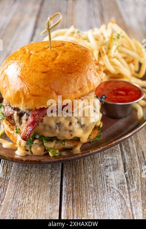 A view of a cheeseburger featuring beer cheese, with a side of french fries. Stock Photo