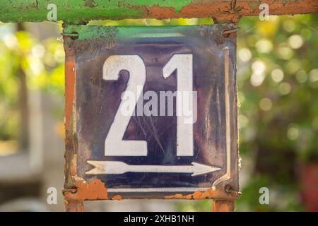 Weathered enameled plate of street address with number 21 Stock Photo