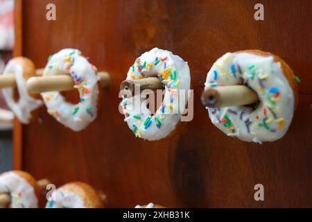 Donuts with colorful sprinkles on a wooden background. Selective focus. Stock Photo