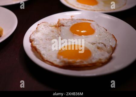 Fried eggs on a plate in a restaurant, close-up Stock Photo