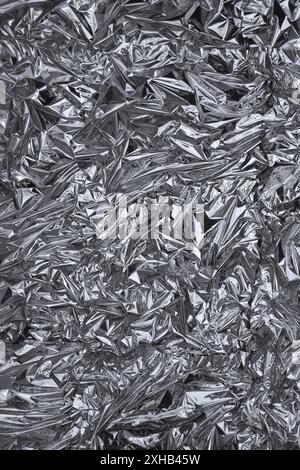 Fullframe crumpled silver foil shining texture background. Stock Photo