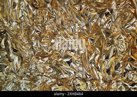 Fullframe crumpled golden foil shining texture background. Stock Photo