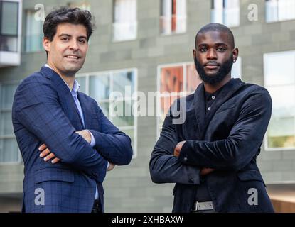 closeup black African businessman and a Hispanic counterpart, both dressed impeccably in suits, stand with crossed arms, exuding confidence and profes Stock Photo