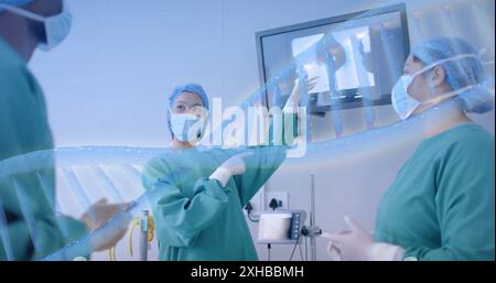 Medical professionals discussing patient data on screen in hospital setting. Healthcare, doctors, teamwork, technology, diagnosis, treatment Stock Photo