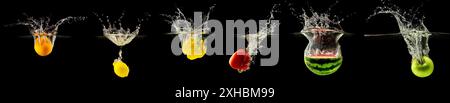 Group of falling fruits and vegetables in water with splash on black background. Stock Photo