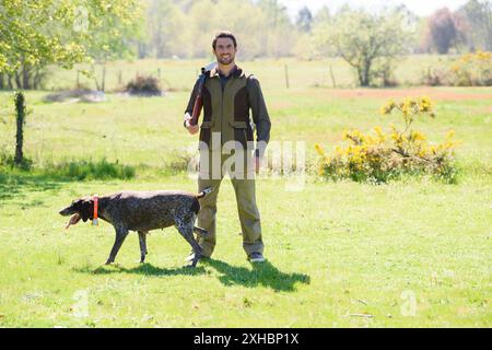 portrait of man holding gun with his dog Stock Photo