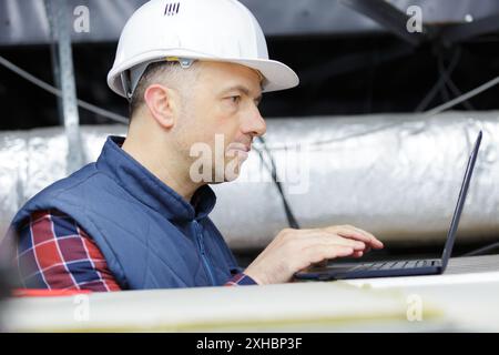 engineer working with laptop in ceiling Stock Photo