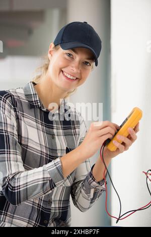 young female electrician using multimeter Stock Photo