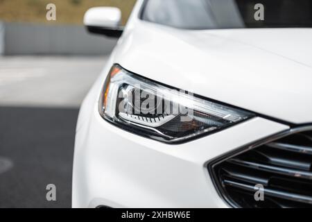 Modern beautiful SUV white car with optics headlight in the city, close-up Stock Photo