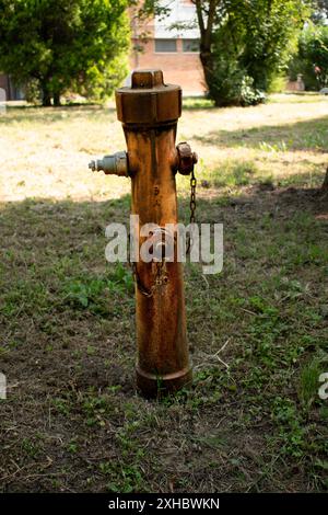 Old fire hydrant next to the sidewalk of a residential condominium, Italy Stock Photo