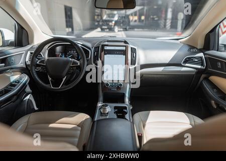 Modern car interior with steering wheel, display and front seats Stock Photo