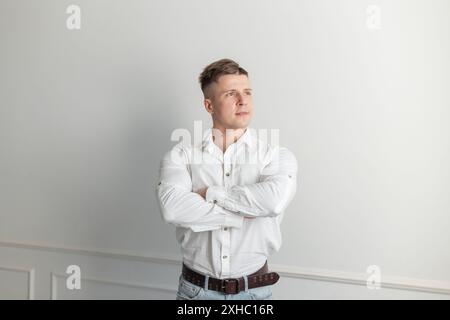 Stylish handsome successful man manager with hairstyle in white shirt on white background Stock Photo