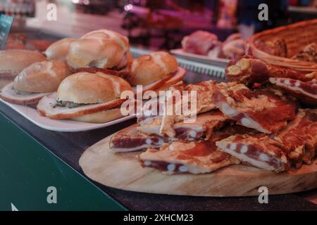 A close-up view of freshly made pork belly sandwiches and sliced pork belly on display at a market or deli. Stock Photo