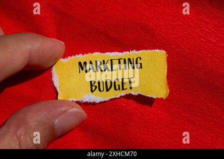 Marketing budget words written on ripped yellow paper with red background. Conceptual marketing budget symbol. Copy space. Stock Photo