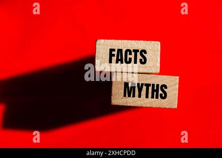 Facts and myths words written on wooden blocks with red background. Conceptual facts and myths symbol. Copy space. Stock Photo