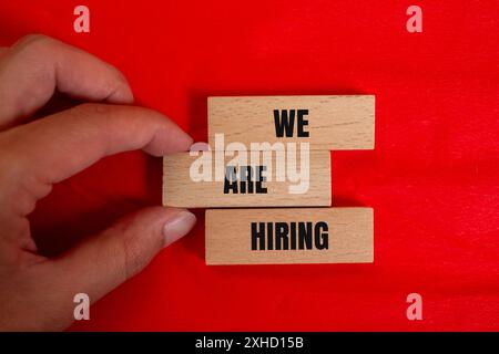 We are hiring message written on wooden blocks with color background. Conceptual we are hiring symbol. Copy space. Stock Photo