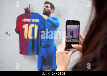 Graffiti by the artist TV Boy featuring Leo Messi holding an FC Barcelona jersey with Lamine Yamal's name and the number 10, along with the words 'The Stock Photo