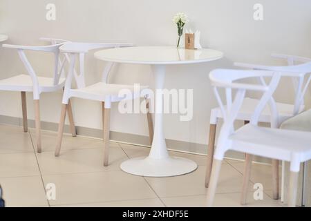 There is a round white plastic table and chairs in the cafe. The table is made of plastic and has a round shape. There is a place to copy. High quality photo Stock Photo