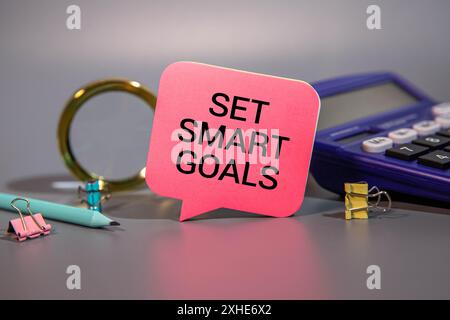 alarm clock,pens and notebook written st smart goals over black background. Stock Photo