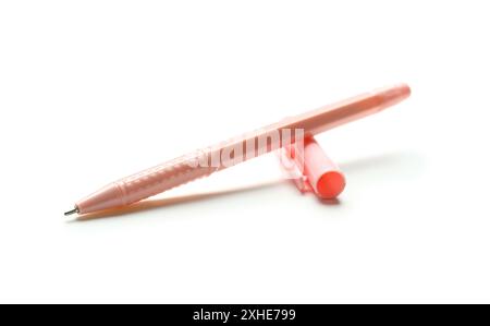 Pink ballpoint pen and cap on white background Stock Photo