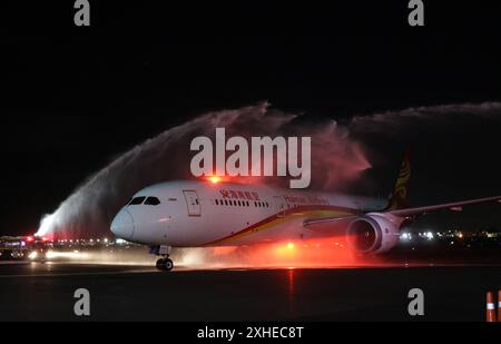 Mexico City, Mexico. 13th July, 2024. A passenger aircraft of China's Hainan Airlines passes a welcome water gate at the Benito Juarez International Airport in Mexico City, Mexico, July 13, 2024. A new direct air route linking Beijing, the capital of China, with Mexico City, was launched on Saturday, with a stopover in Tijuana. Credit: Francisco Canedo/Xinhua/Alamy Live News Stock Photo