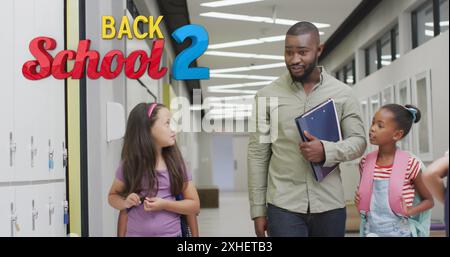 Image of back 2 school text over happy diverse male teacher and schoolgirls talking in corridor Stock Photo