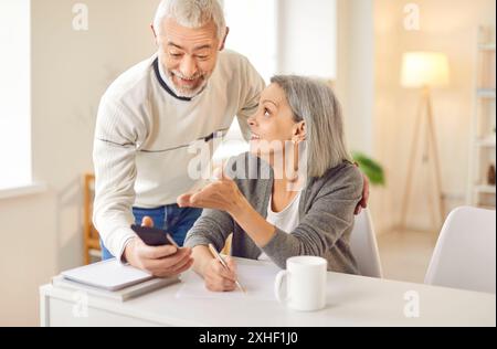 Senior couple smartphone using, older adults learn how to interact with phone digital information Stock Photo