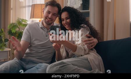 Happy couple family Caucasian man guy male husband boyfriend Hispanic Latino woman girl female wife girlfriend smiling laughing discuss shopping Stock Photo