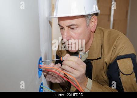 electrician installing socket Stock Photo