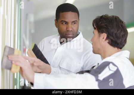 male supervisor teaching apprentice painter Stock Photo